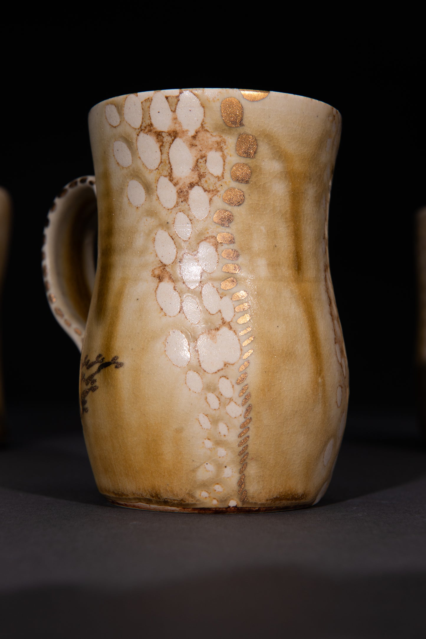 Ceramic mug with unique dotted glaze pattern on a dark background