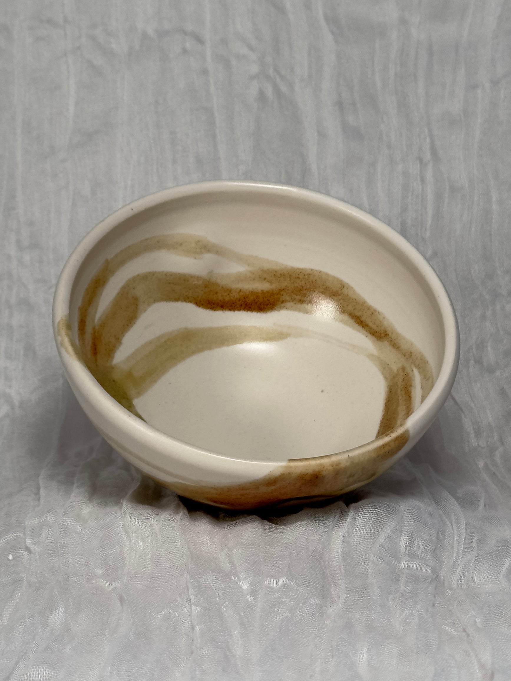 Small ceramic bowl with brown accents on a gray background