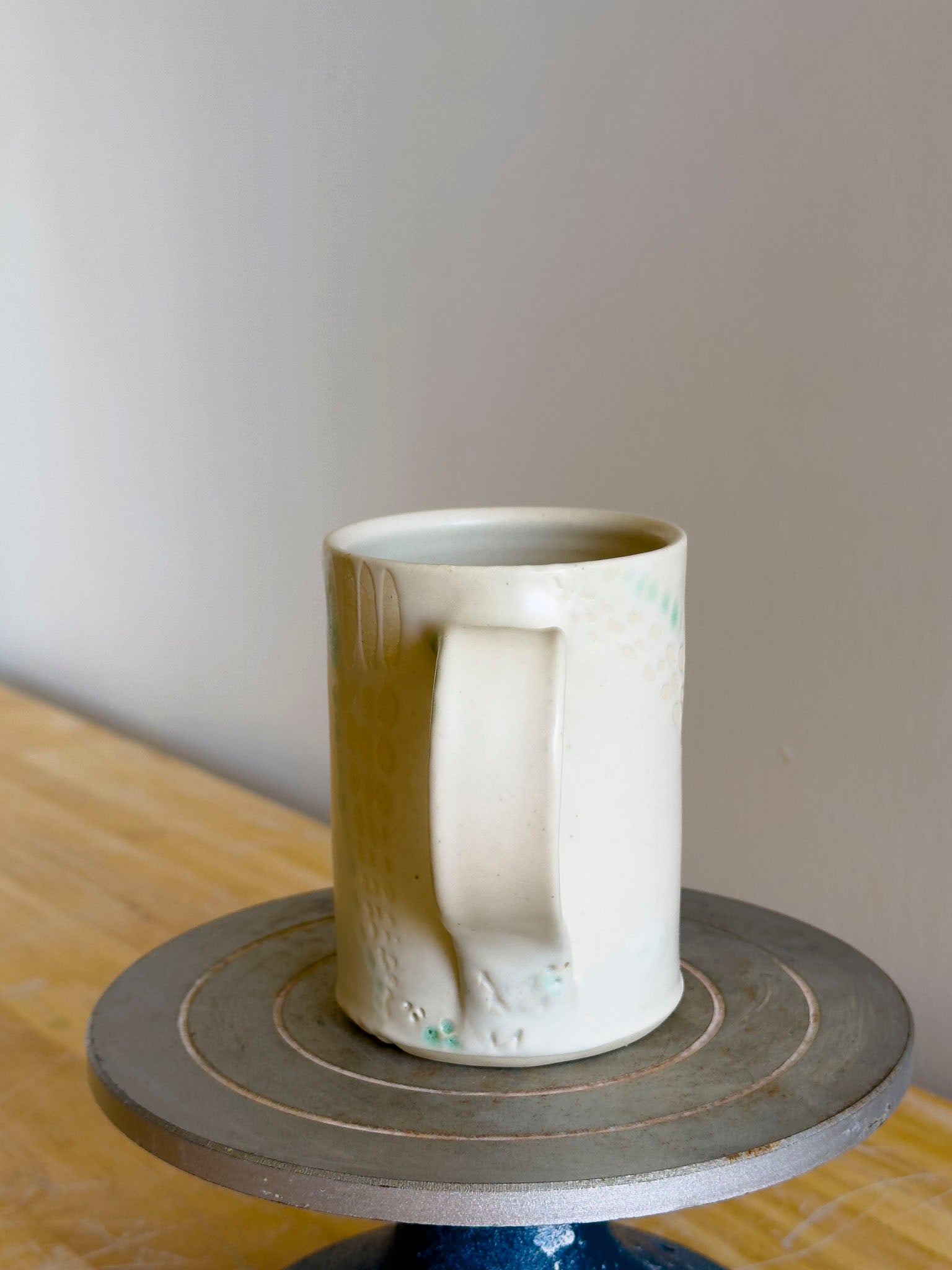 White ceramic mug on a wooden surface with a plain background