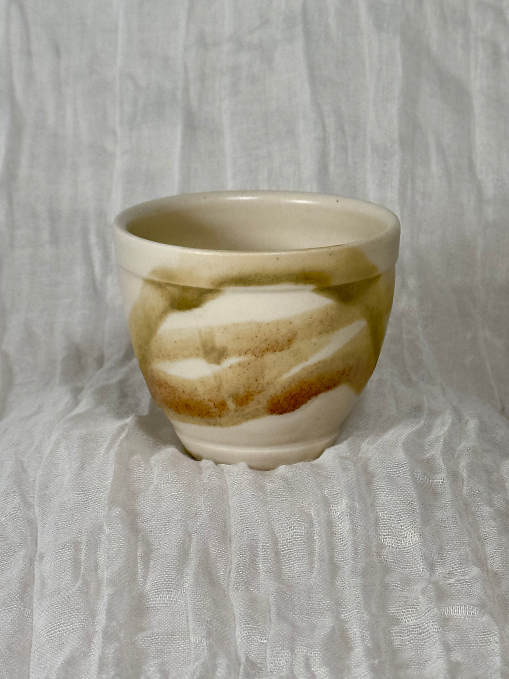 Ceramic cup with marbled design on a textured gray background