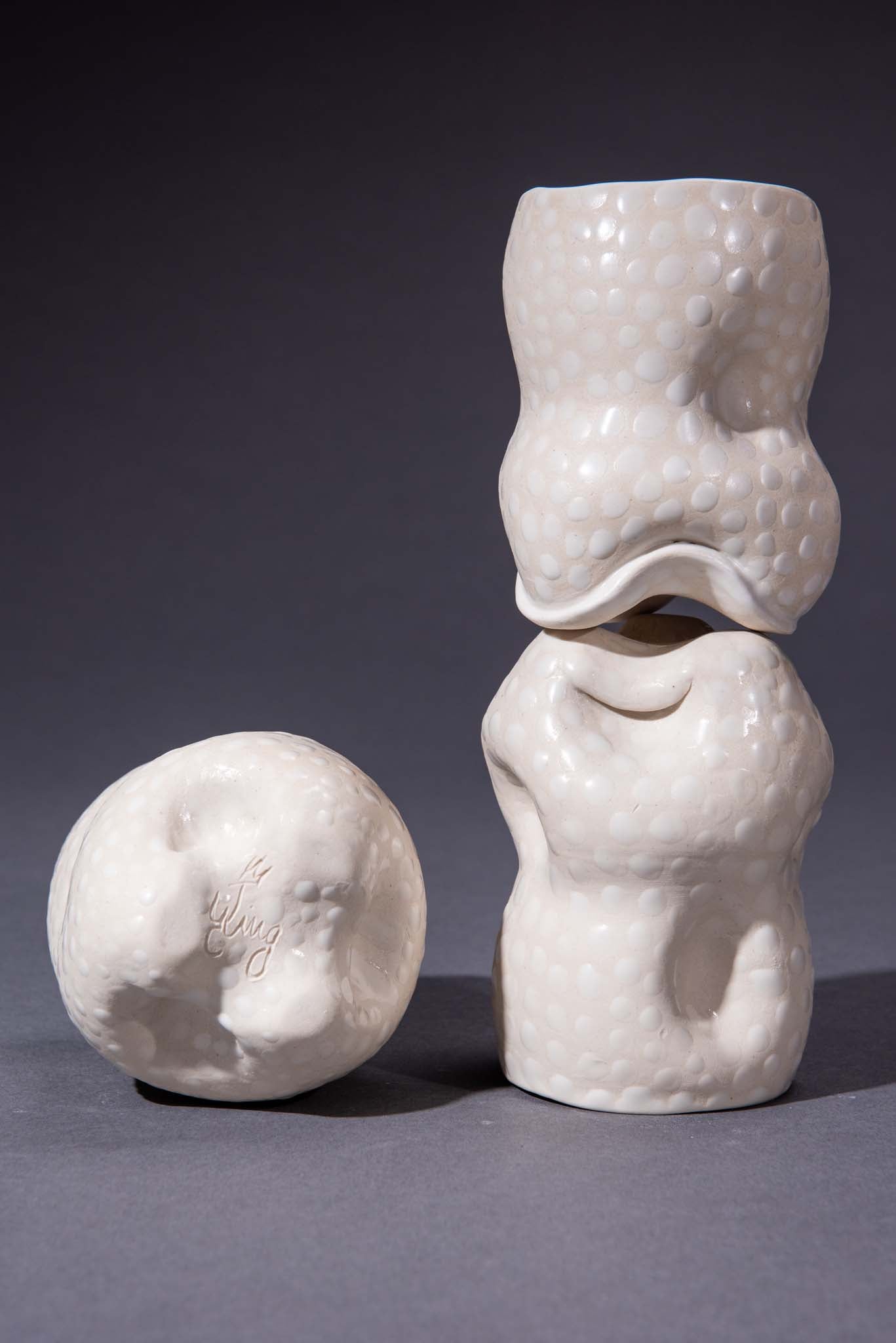 White ceramic sculptural cups on a gray background