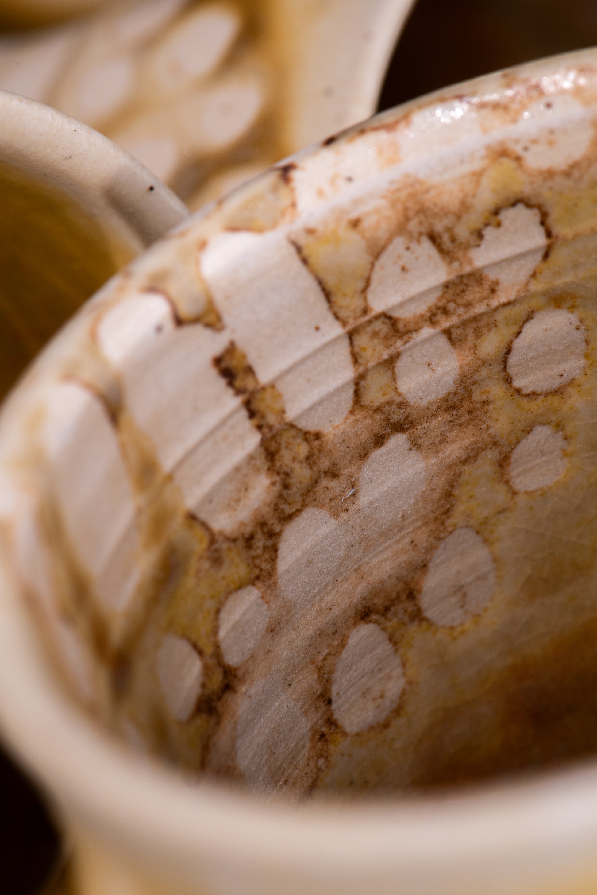 Close-up of a ceramic mug with a handmade dotted pattern of bare clay