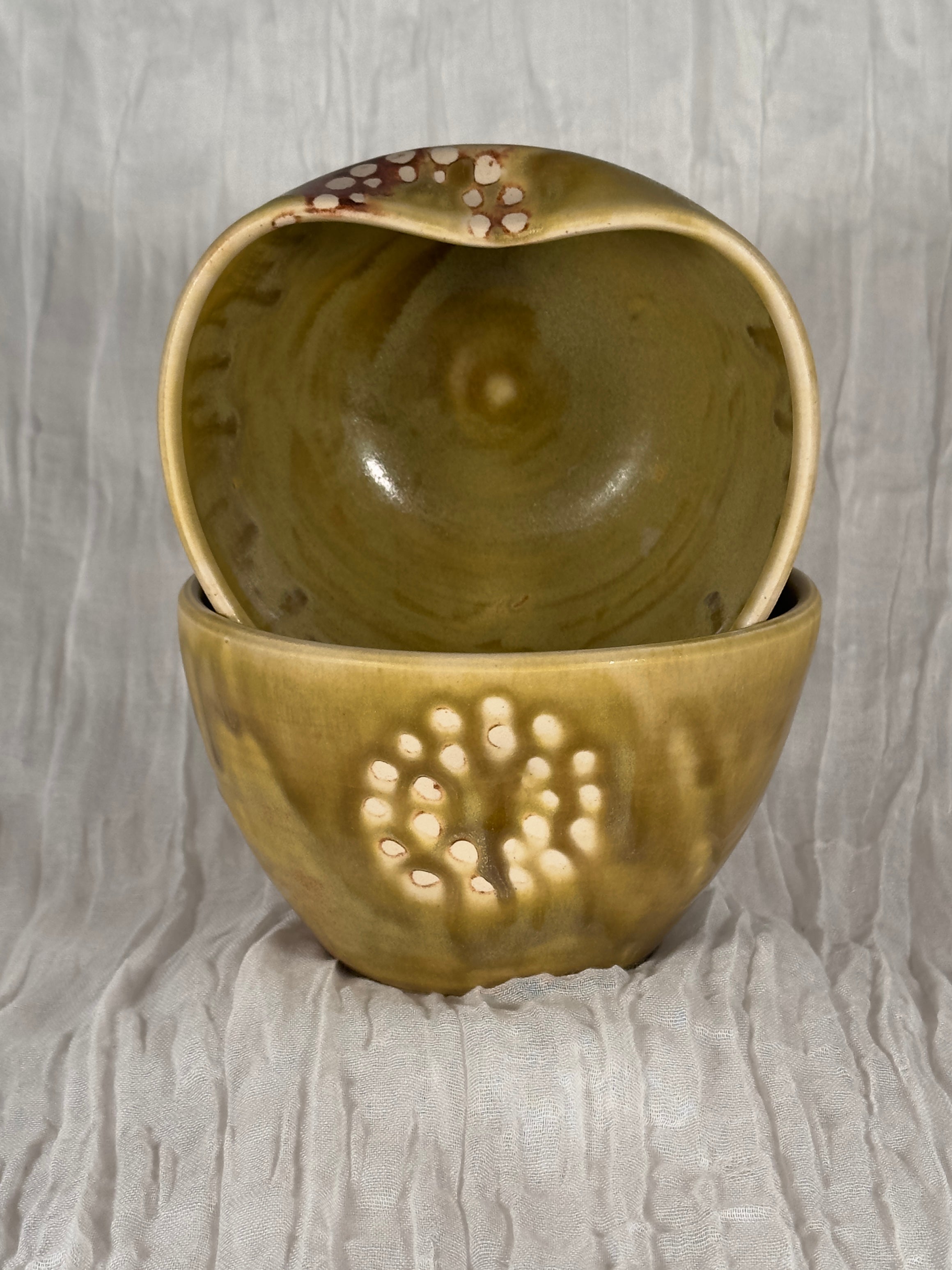 Two ceramic bowls with textured surface on a gray background