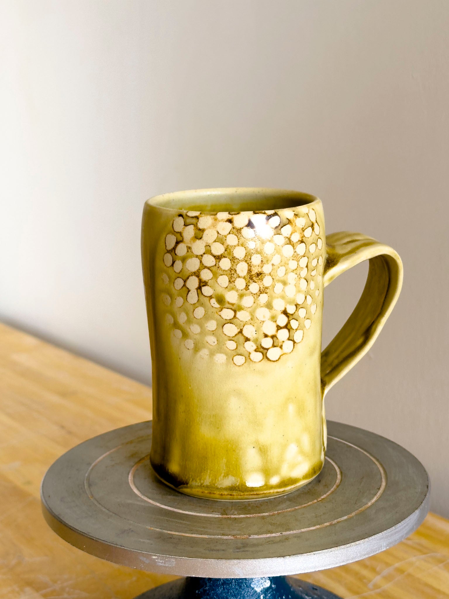 Gold mug with a textured pattern on a wooden surface