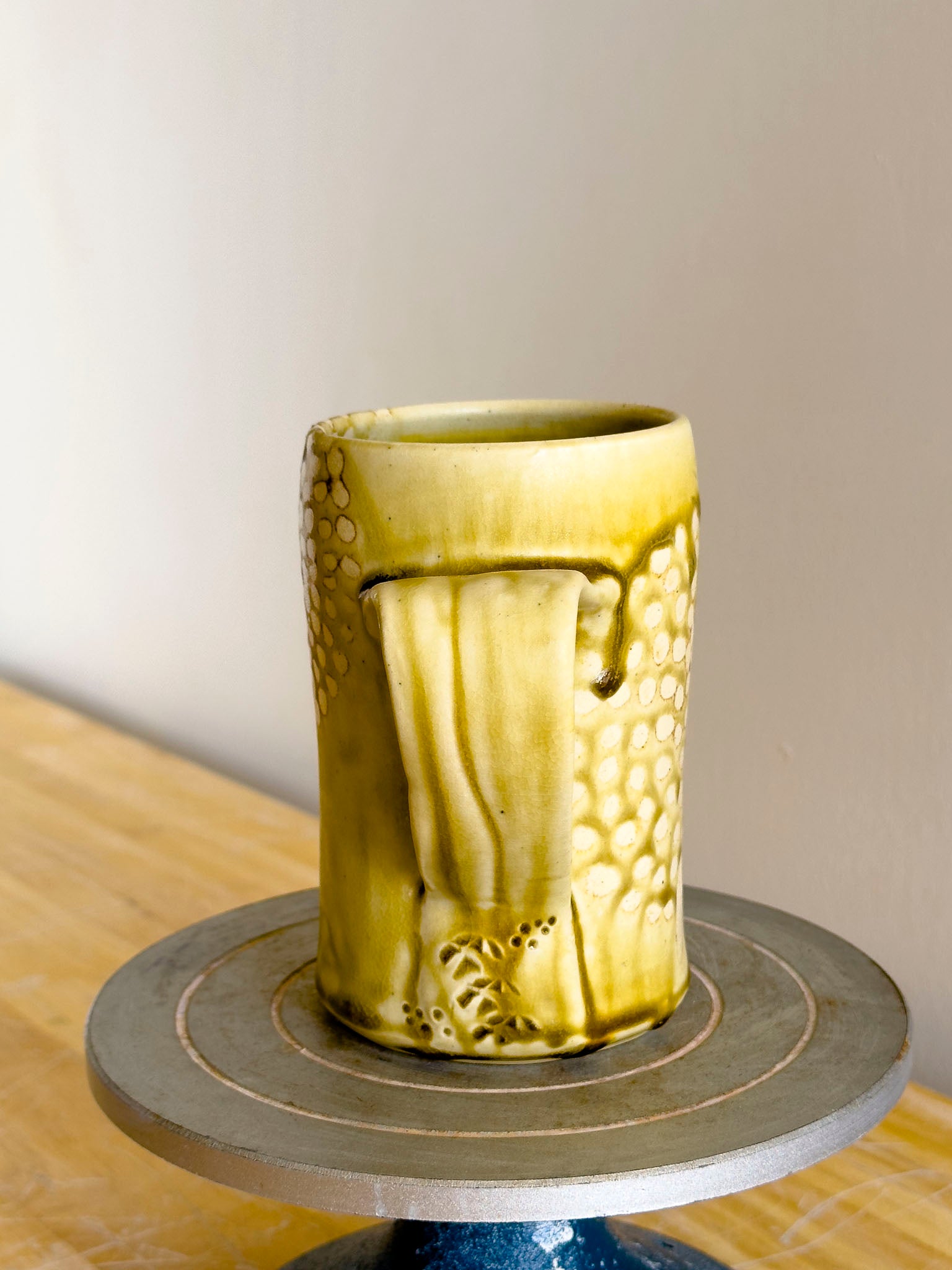 Golden ceramic mug on a wooden surface with a neutral background