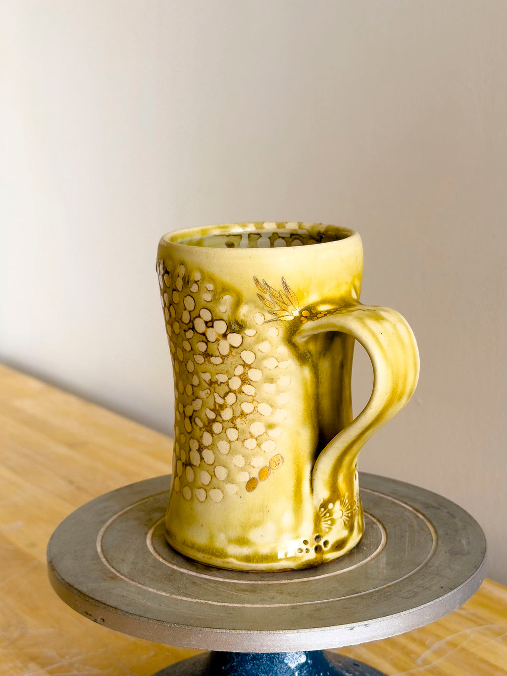 Yellow ceramic mug on a wooden surface with a neutral background