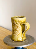 Yellow ceramic mug on a wooden surface with a neutral background