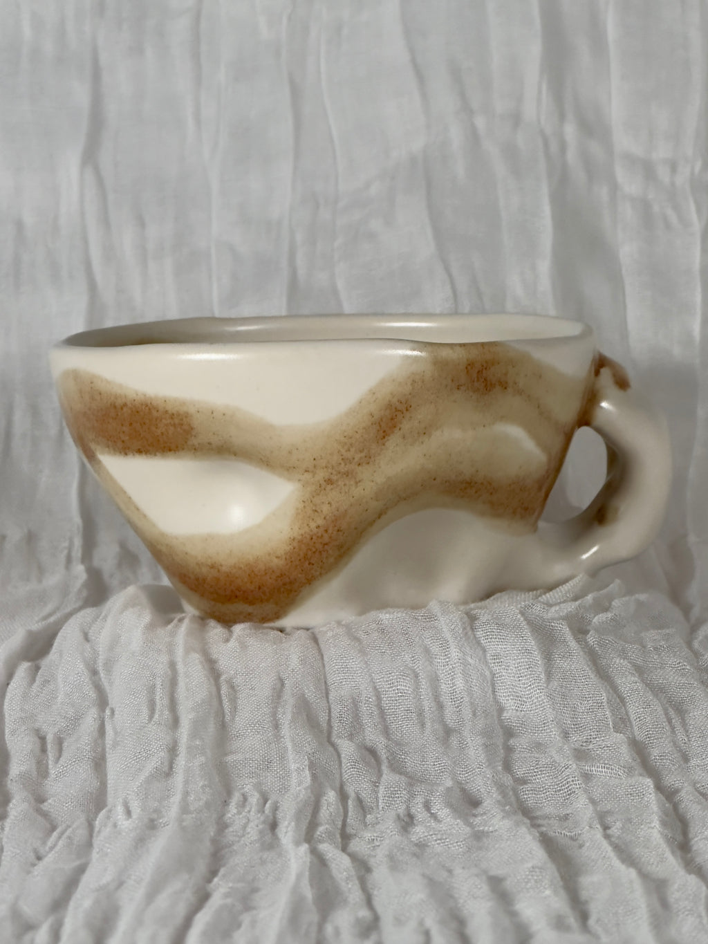 Ceramic mug with a textured surface on a textured white background